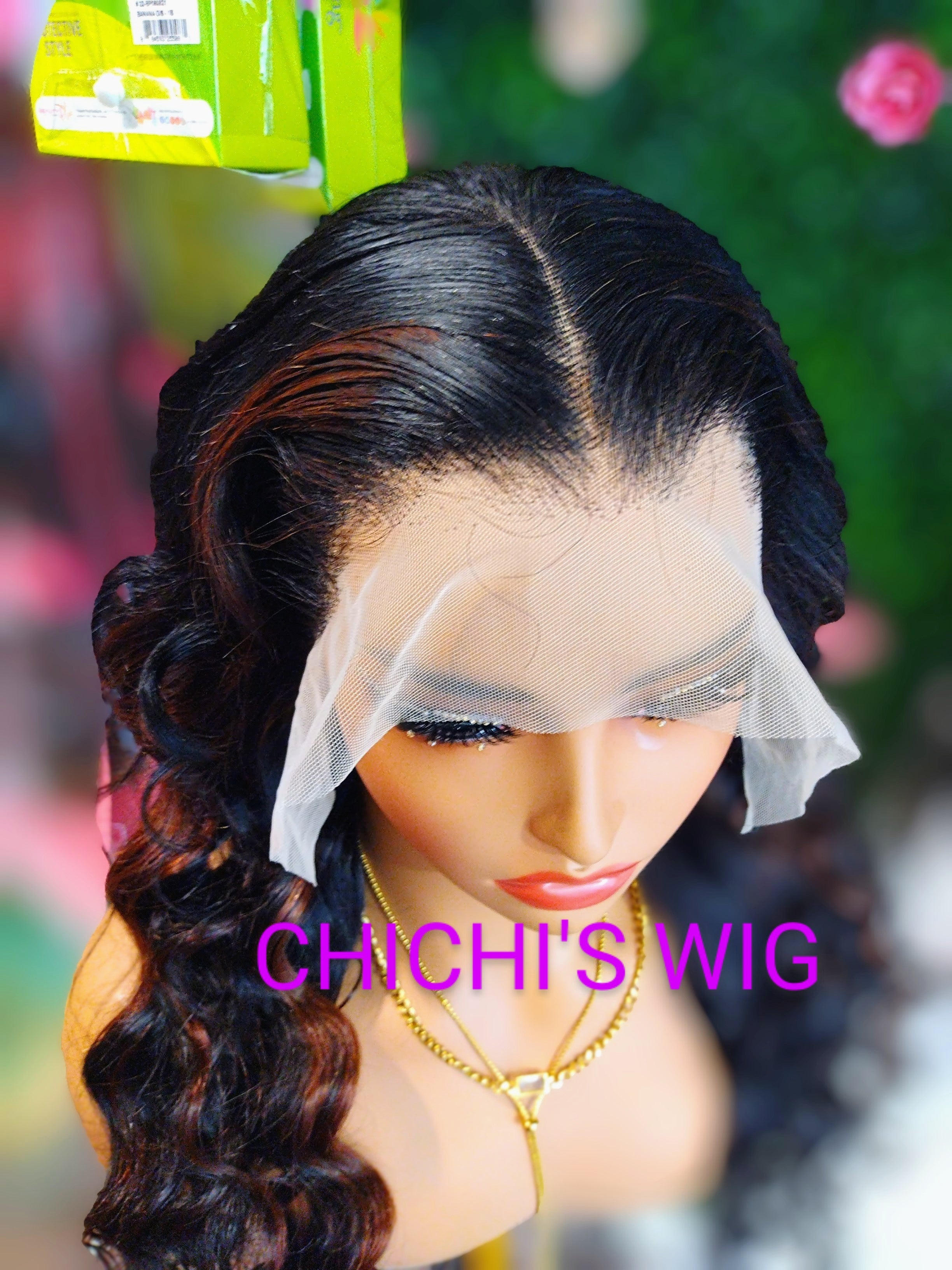 Mannequin head with a wig and 'CHICHI'S WIG' branding in a blurred outdoor setting.